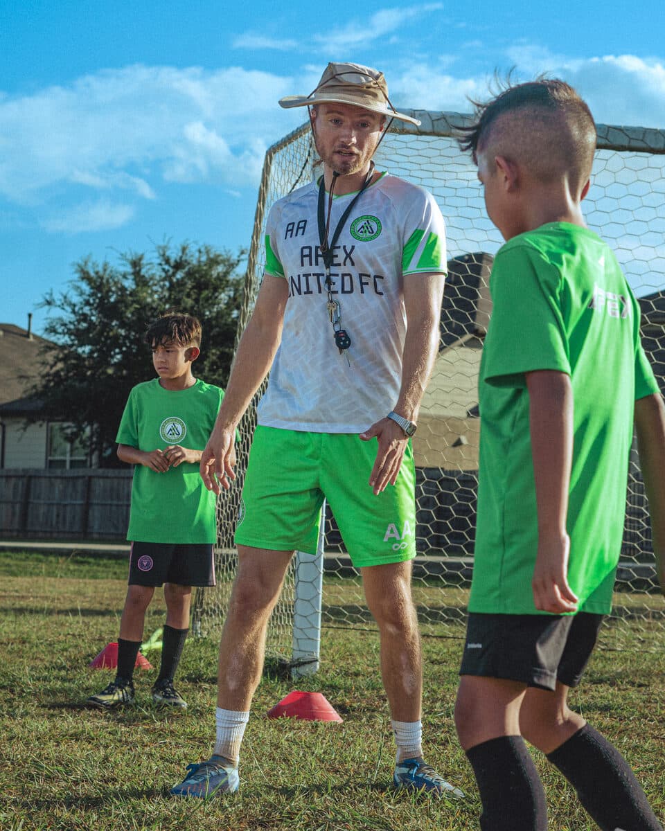 Apex United FC coach mentoring a young player in San Antonio