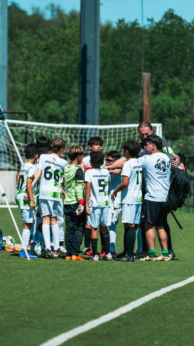 Apex United FC team huddle on the pitch in San Antonio
